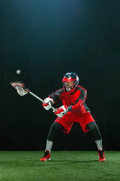 Jogador de lacrosse, atleta desportista de capacete vermelho sobre fundo escuro. Esporte e motivação papel de parede. — Fotografia de Stock