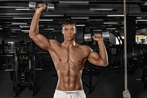 Muscular man athlete in fitness gym have havy workout. Fitness sports trainer on trainging with dumbbells. Full body workout. — Stock Photo, Image