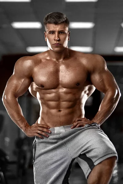 Kehonrakentaja athlet mies pumppaa lihaksia kuntosalilla. Brutaali vahva lihaksikas kaveri kuntoilussa. Kehonrakennuksen käsite. — kuvapankkivalokuva