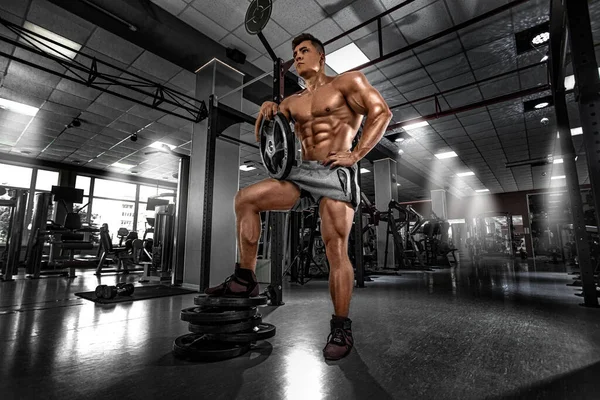 보디빌더는 사람들이 체육관에서 근육을 부풀리게 하였다. 근육질의 잔인 한 근육질의 남자가 운동하고 있어. 육체미 운동. — 스톡 사진