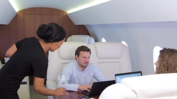 Two businessmen comfortably work on private plane — Stock Video