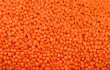 Kırmızı mercimek dokuyu kapatır. Sağlıklı organik baklagiller, yemek pişirmek için kullanılan çiğ darbeler, vejetaryen diyeti, protein kaynağı ve tam bir çerçevede izole edilmiş mutfak malzemeleri.