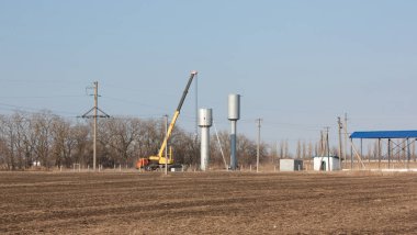 Krasnodar, Rusya Federasyonu - 18 Mart 2012: Bir vinç bir su kulesi yükler. Bir adam askılar giderir