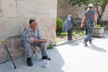 Bir Gürcü müzik aleti kilise duvarları yakınında bir adam Mtsheta, Georgia - 17 Ağustos 2013: