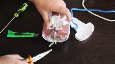Bir adam bir elektrik demir onarır. Adamın elleri yakın çekim