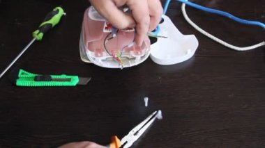 Bir adam bir elektrik demir onarır. Adamın elleri yakın çekim