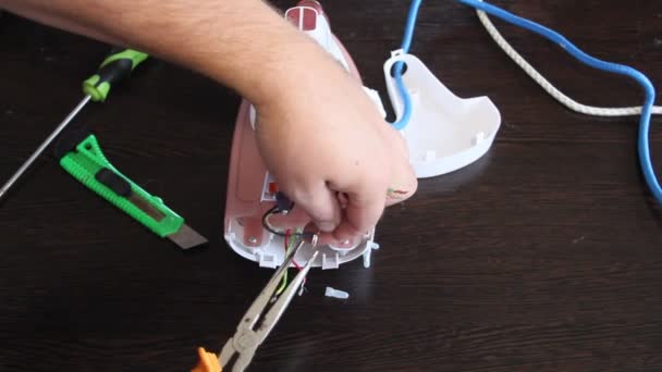 男は電気アイロンを修復します 人間の手のクローズ アップ — ストック動画