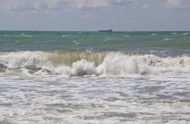 Büyük dalgalar kıyıya gürüldüyor. Geminin fırtınalı denizde yelken