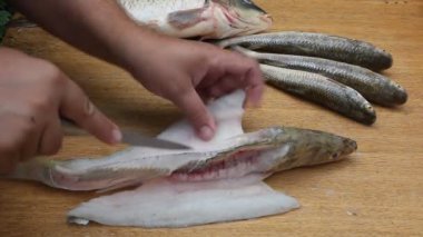 Adam bir bıçakla balığı kesti. Eller ve balıklar yakın plan.