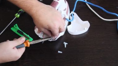 Bir adam bir elektrik demir onarır. Adamın elleri yakın çekim