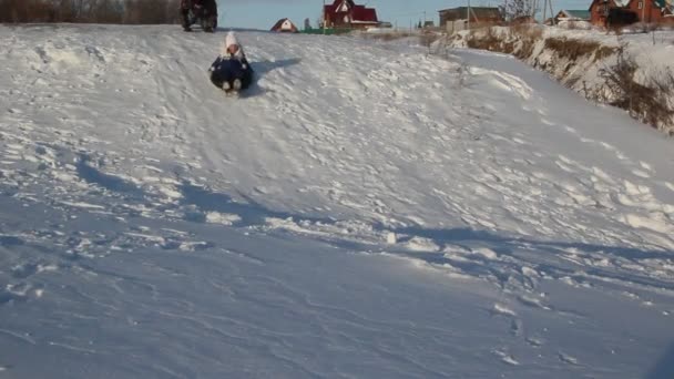 Zonnige Winterdag Een Klein Meisje Paardrijden Een Sneeuw Dia — Stockvideo