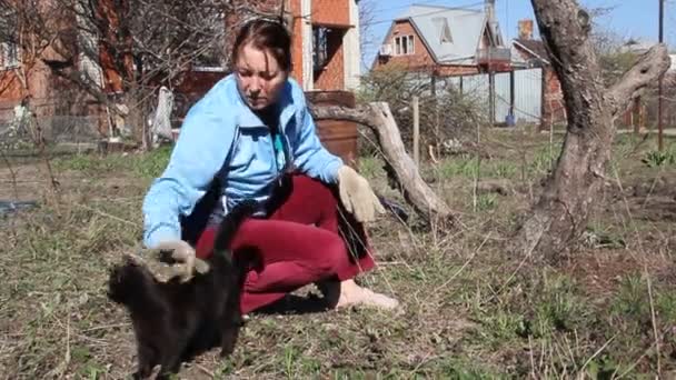 Kobieta Czarny Kot Kobieta Średnim Wieku Pracuje Ogrodzie Obok Czarnego — Wideo stockowe