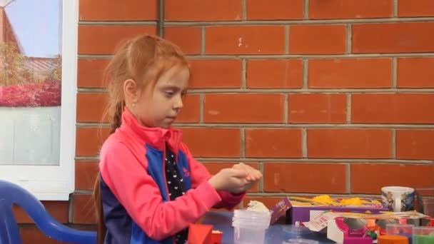 Ένα Όμορφο Κορίτσι Κόκκινα Μαλλιά Στο Τραπέζι Κορίτσι Που Παίζει — Αρχείο Βίντεο