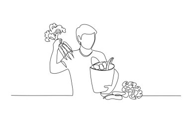 Adam havucu alışveriş poşetinden çıkarıyor.