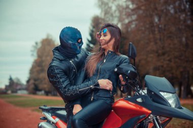 Spor motosikletli güzel bir hippi kızın portresi. Kafatası maskeli bir adamla.