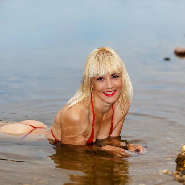 湿惊人的女人在比基尼 穿着比基尼在水里的漂亮女孩 在岸上摆姿势的健身模型 — 图库照片