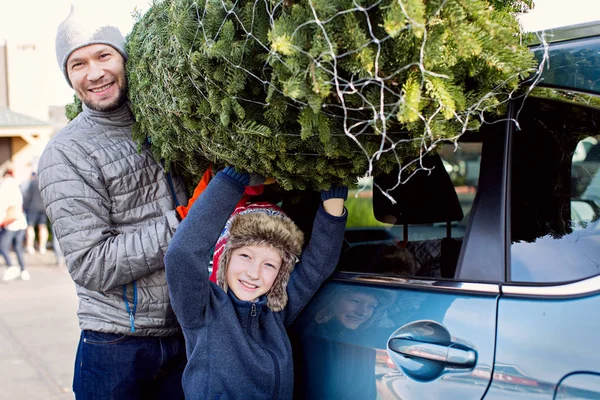 幸せな家族のクリスマス ツリー ショッピング 車の屋根からツリーを取って 一緒に魔法の時間を楽しんで — ストック写真