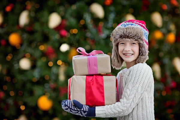 Cute Smiling Little Boy Holding Christmas Presents Decorated Tree Background — Stock Photo, Image