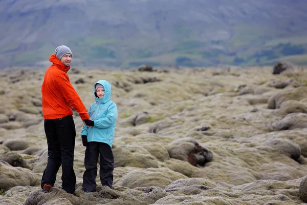 つの家族 父と息子 アイスランド一緒に 活動的な休暇と家族の冒険の概念 コケに覆われた溶岩フィールドを探索コピーの右上の領域 — ストック写真
