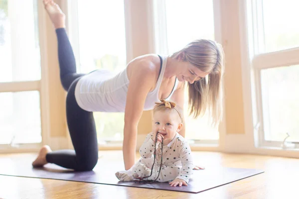 忙しい若い母親が赤ちゃんと一緒に家でヨガのフィットネスをしたり健康的な家族活動の概念 — ストック写真