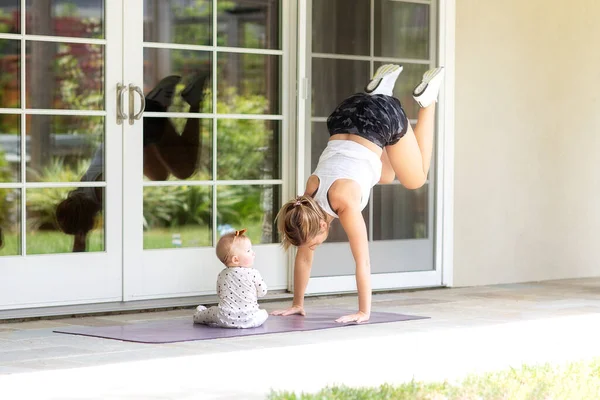 Zajęta Młoda Matka Robi Fitness Domu Wraz Dzieckiem Podczas Pobytu — Zdjęcie stockowe