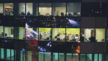 Çerçevede, yüksek katlı bir binada ofisleri windows görebilirsiniz. Sonra kamerayı sağa taşır. Resimde, bir trafik jam büyük bir şehirde.