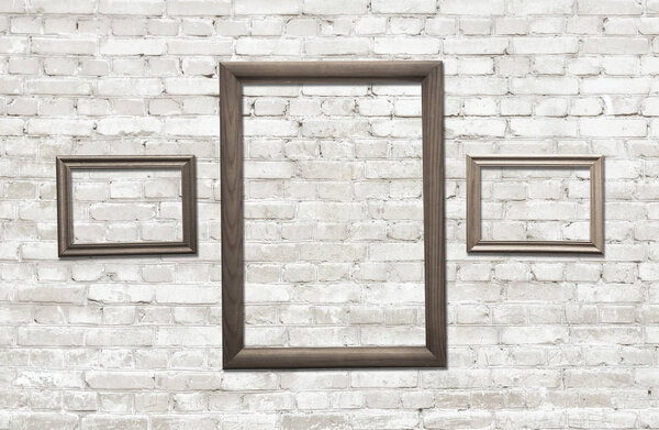 old photo frames on brick wall