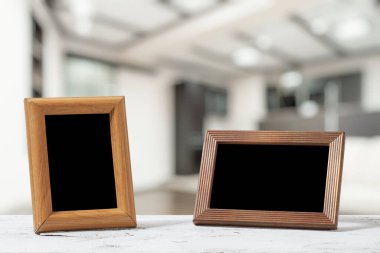 Oturma odasındaki ahşap masada fotoğraf çerçeveleri.