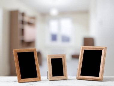 Oturma odasındaki ahşap masada fotoğraf çerçeveleri.