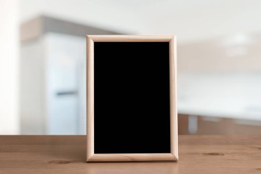 Oturma odasındaki ahşap masada fotoğraf çerçevesi.