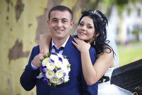 Glückliche Braut Mit Einem Strauß Umarmt Den Bräutigam Von Hinten — Stockfoto