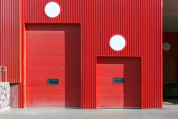 roller shutter gate of different size on red wall of distribution warehouse