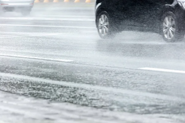 rain in the city. view of wet asphalt road with car traffic in motion