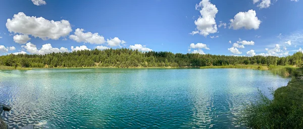 idyllic turquoise colored quarry lake in forest. panoramic summer landscape