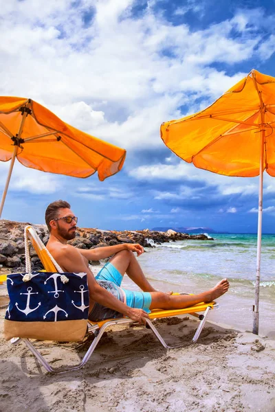 Мужчина Отдыхает Пляже Кресле Загорает Желтым Зонтиком Греция Крит Ираклион — стоковое фото