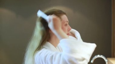 Saçlarını tarayan genç bir kadın..