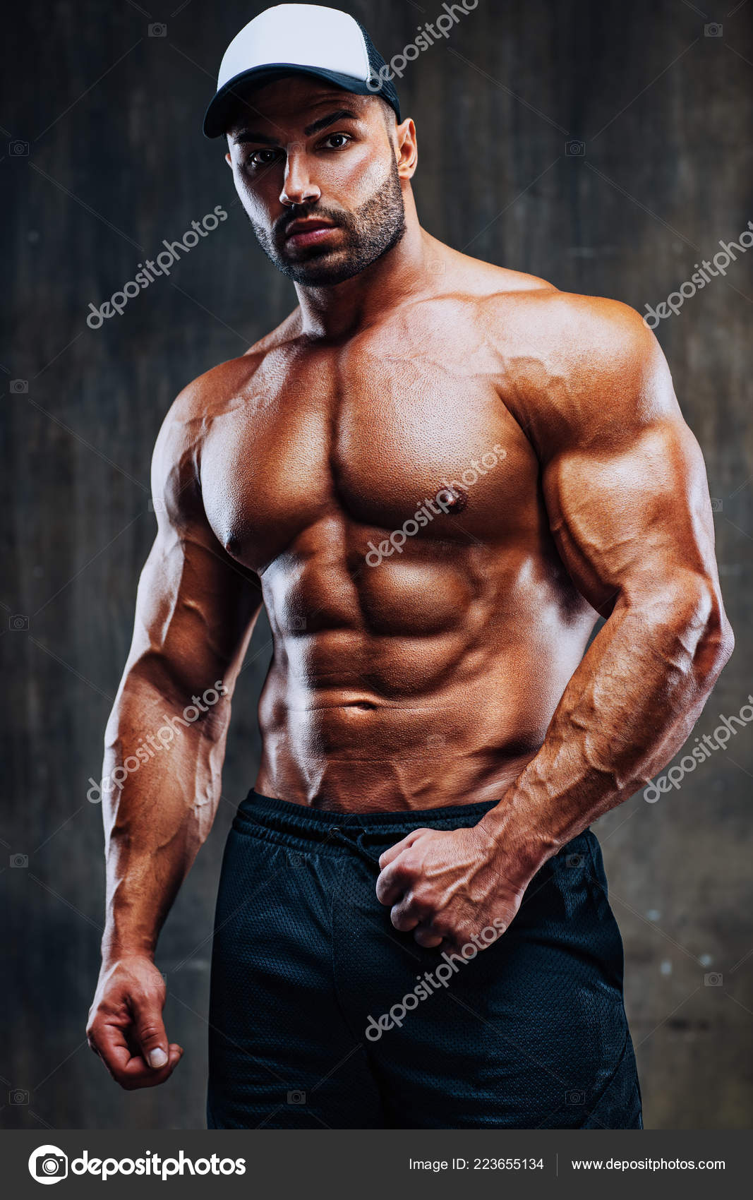Young Strong Man Bodybuilder Cap Stone Wall Background Stock Photo by  ©chaoss 223655134