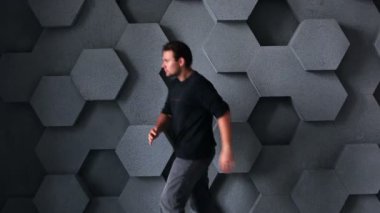 Robot gibi duvar arka plan üzerinde yürüyen adam.