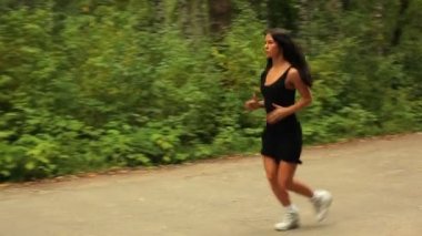 Genç bayan parkta koşuyor..