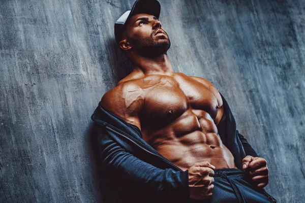 Jeune Homme Fort Bodybuilder Chapeau Sur Fond Mur Regardant Côté — Photo