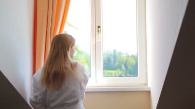 Penceresini açmak ve dışarı arayan genç kadın