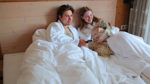Junger Mann Und Frau Mit Hund Sucht Und Schaltet Fernsehsender — Stockvideo