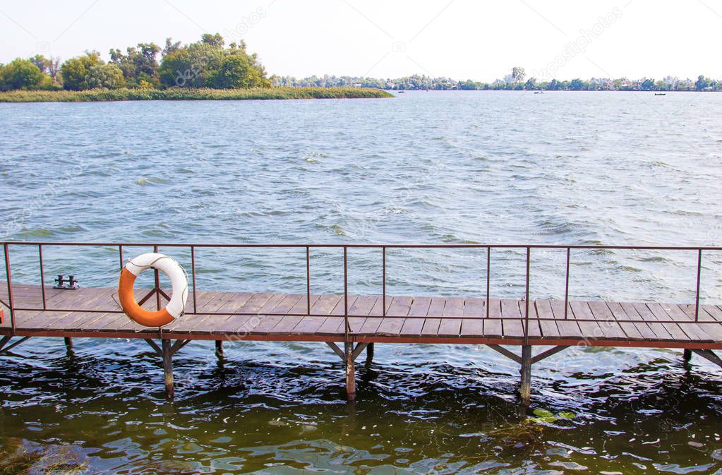 image life buoy hanging on the pier bridge near the water