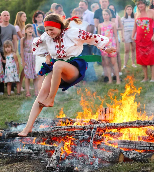 Kiev, Ukrayna - 6 Temmuz 2018: Genç kız Ulusal giyim atlar üzerinde şenlik ateşi Pirogovo açık hava Ukrayna Halk Müzesi Ivana Kupala tatil geleneksel Slav kutlama sırasında alevler içinde
