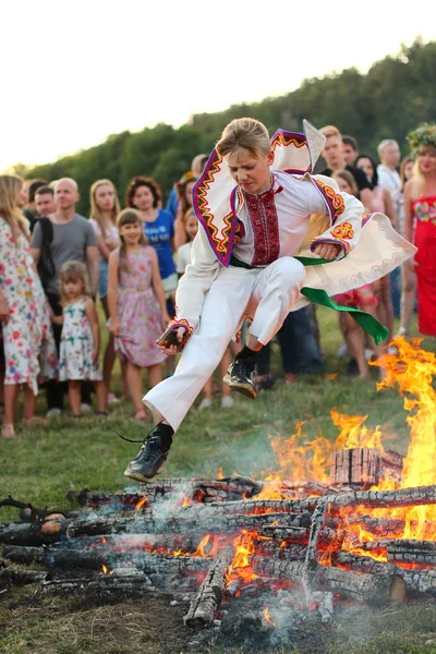 Kiev, Ukrayna - 6 Temmuz 2018: Genç insanlar Pirogovo açık hava Ukrayna Halk Müzesi Ivana Kupala tatil geleneksel Slav kutlama sırasında şenlik ateşi alevler atlamak