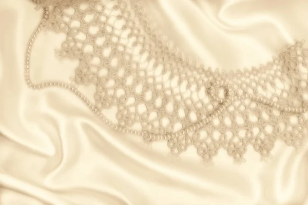 光滑典雅的金丝或带有珍珠和花边的缎子可用作婚礼背景 塞皮亚的口气变了 复古风格 — 图库照片