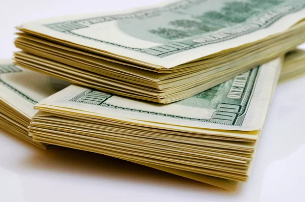 Paquetes de efectivo en dólares estadounidenses por valor de cien dólares en una luz ba — Foto de Stock
