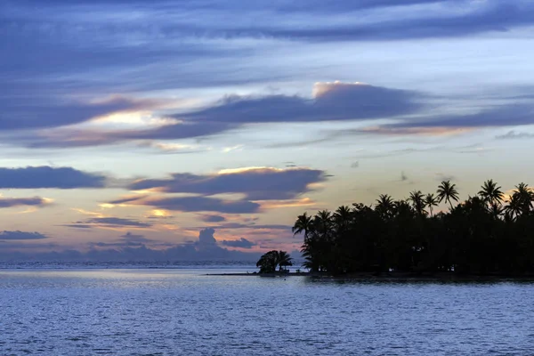 Beautiful sunset over the small island on the Pacific ocean in the Leeward group of the Society Islands of French Polynesia.