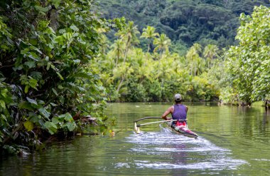Fransız Polinezyası, Tahaa, 29 Aralık 2017 - Polinezya adam Tahaa ada Fransız Polinezyası üzerinde bir nehir kanosu.