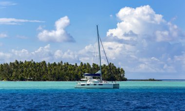 Pupa grup Fransız Polinezyası toplum Adaları Tahaa Adası arka plan üzerinde turkuaz lagün içinde yalnız Katamaran.
